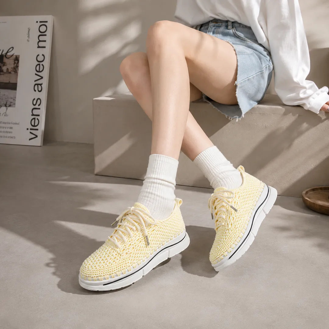 Lemon yellow handmade crochet knit sneakers worn on feet with white socks and denim shorts — artisan platform custom shoes
